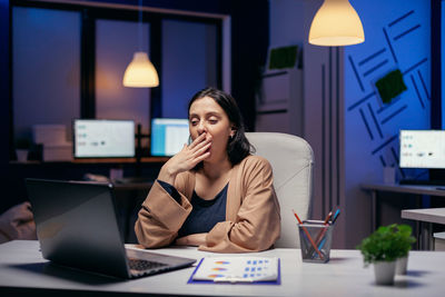 Woman using mobile phone while sitting on table