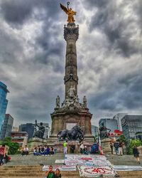 People at town square against cloudy sky