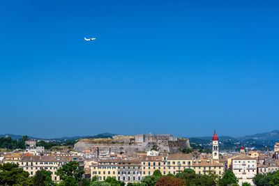 Aerial view of townscape against blue sky