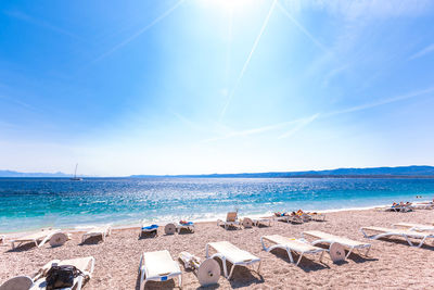 Scenic view of beach against blue sky on sunny day