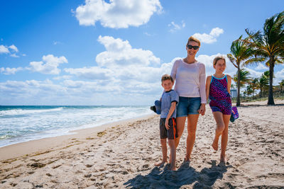 Mother with children standing at beach