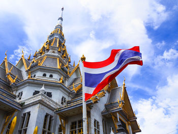 Low angle view of flags on building against sky