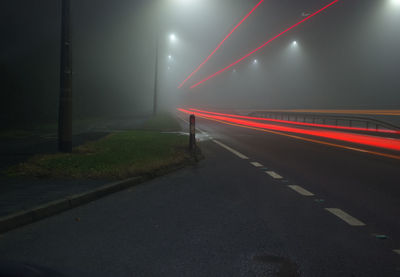 Light trails on road against sky at night