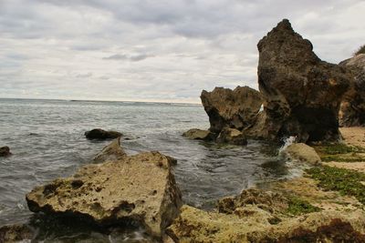 Rocks on sea shore against sky