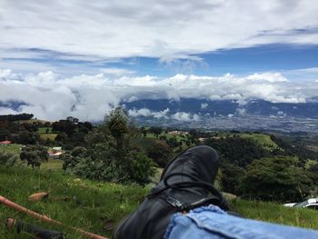 Low section of man on landscape against sky