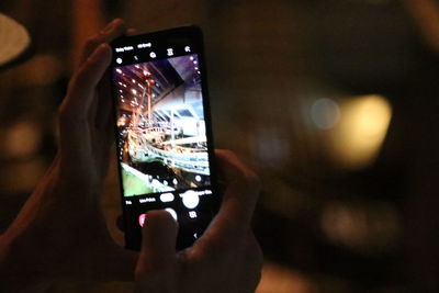 Close-up of hand holding mobile phone at night