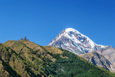 View of mount kazbek and gergeti trinity church from stepantsminda town in autumn, georgia