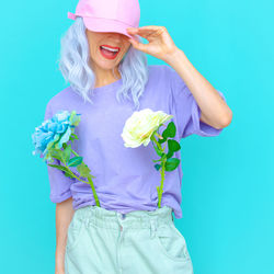 Smiling of woman with flowers against colored background