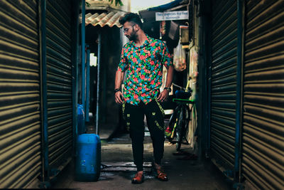 Young man standing in narrow alley