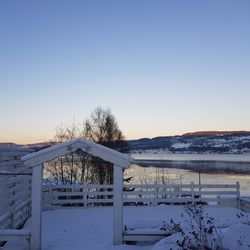 Snow covered landscape against clear sky