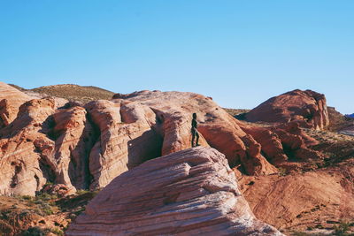 Woman standing on rock formation in valley of fire