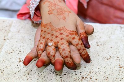 Close-up of adult and child hands with henna