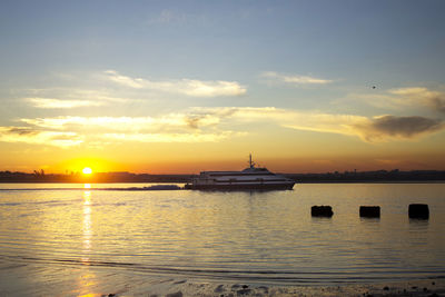 Sailboats in sea against sky during sunset