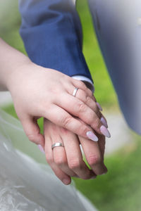 Midsection of couple holding hands