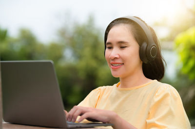 Portrait of teenage girl using mobile phone outdoors