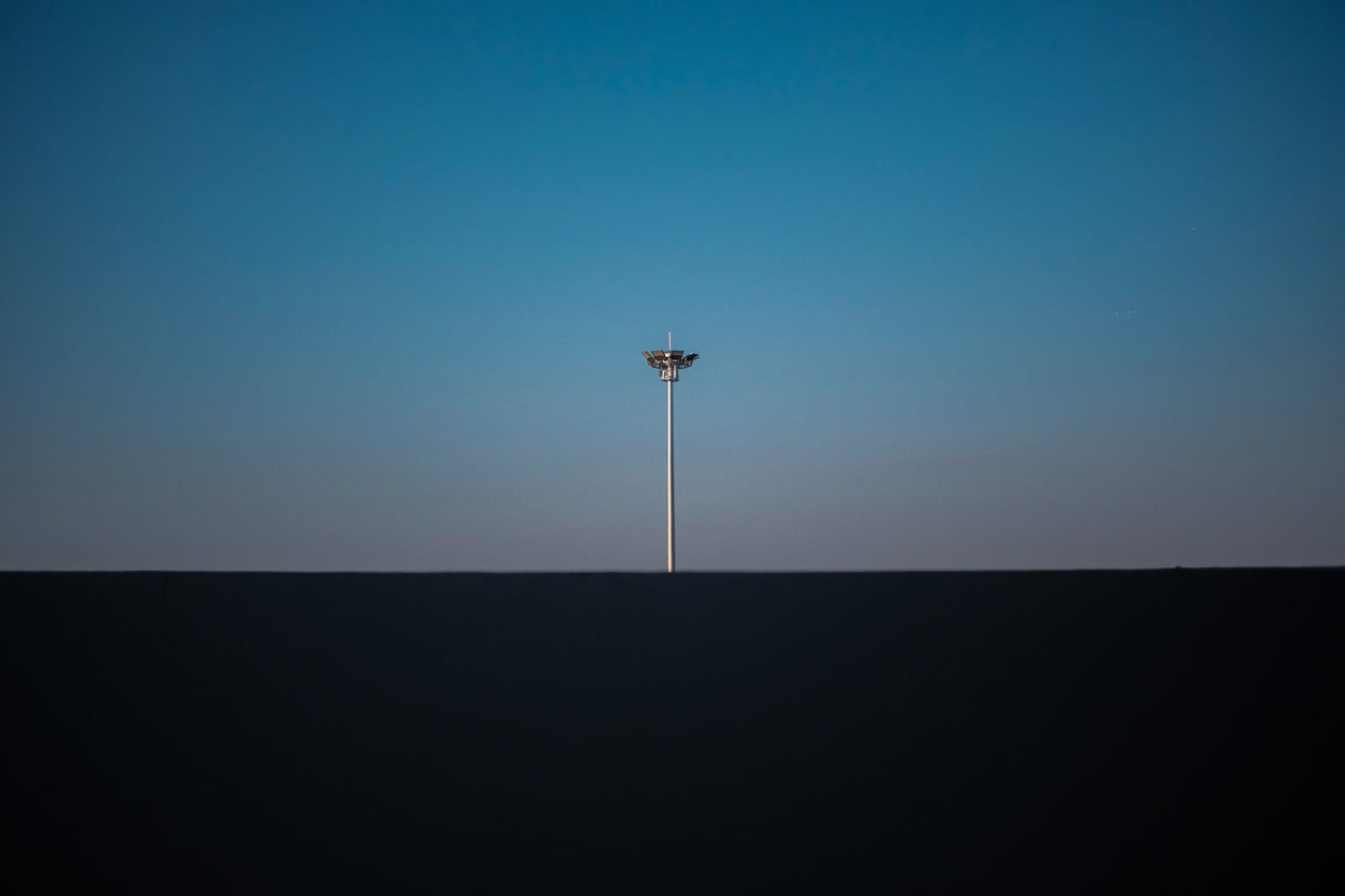 LOW ANGLE VIEW OF COMMUNICATIONS TOWER AGAINST CLEAR BLUE SKY