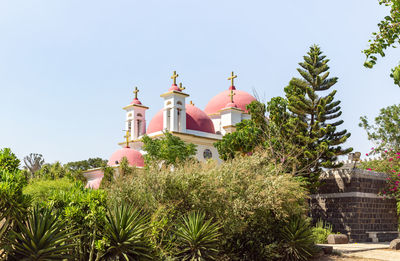 Low angle view of trees and building against sky