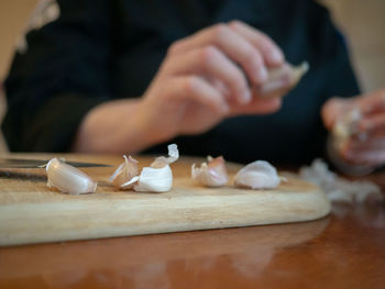 Midsection of person preparing food on cutting board at home