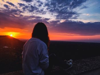 Man standing by sea against sky during sunset