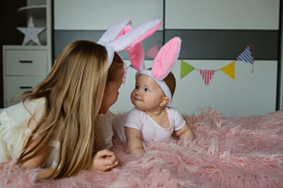 High angle view of mother and daughter standing against wall