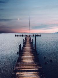 Pier over sea against sky during sunset