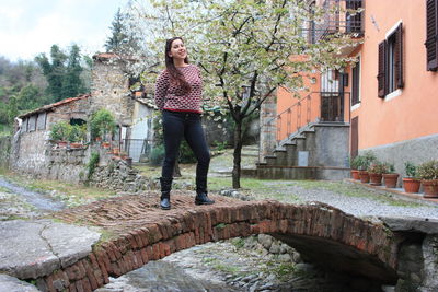 Full length of woman standing by tree