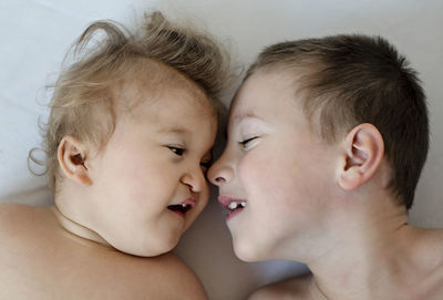 High angle view of siblings on bed