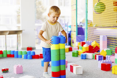 Boy playing with toy blocks in gym