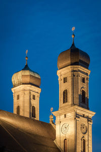 Low angle view of clock tower against blue sky