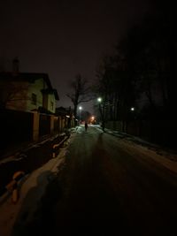 Street amidst illuminated buildings in city at night