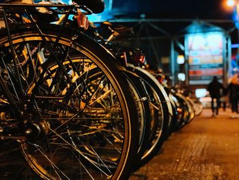 Close-up of bicycle parked on street in city at night