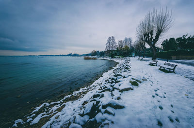 Scenic view of lake against cloudy sky during winter