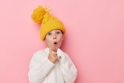 Portrait of cute girl gesturing against pink background