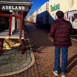 Rear view of man standing on road in city