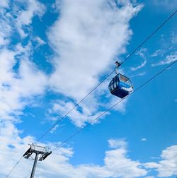 Low angle view of overhead cable cars against sky