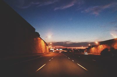 Close-up of wet highway in city at night