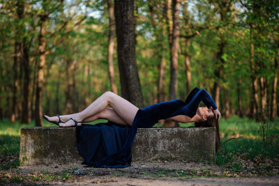 Woman relaxing on land in forest