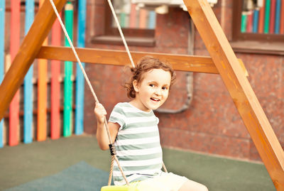 Happy boy playing on slide at playground