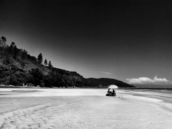 View of calm beach against clear sky