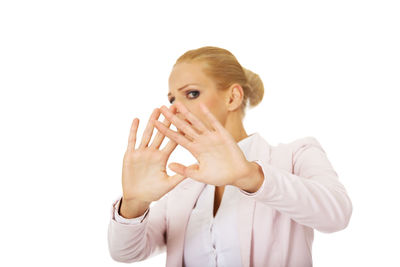 Portrait of young woman standing against white background