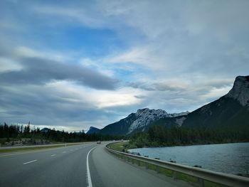 Road by mountains against sky