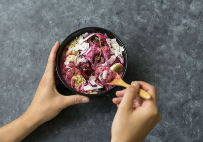 View of person holding bowl of ice cream with fresh fruits