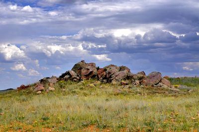 Rocks on field against sky