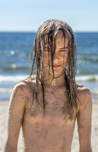 Portrait of young woman standing at beach