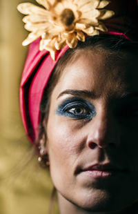 Close-up portrait of young woman with flower on head