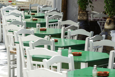 Chairs and tables in swimming pool against building