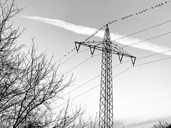 Low angle view of electricity pylon against sky