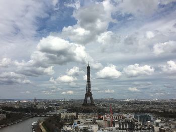 Aerial view of buildings in city against cloudy sky