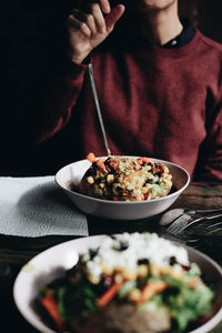 Midsection of man having food in bowl