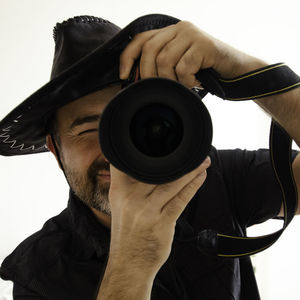 Low angle close-up of man photographing with camera against clear sky